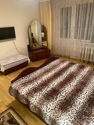 a bedroom with a large bed and a mirror at Ground floor apartment close to city centre and tourist attractions in Druskininkai