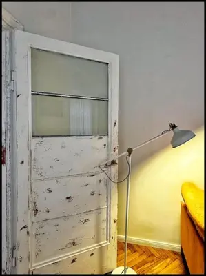 a door in a room with a lamp and a bed at Kauno Centras in Kaunas