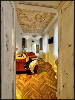 a room with a bed and a living room at Kauno Centras in Kaunas