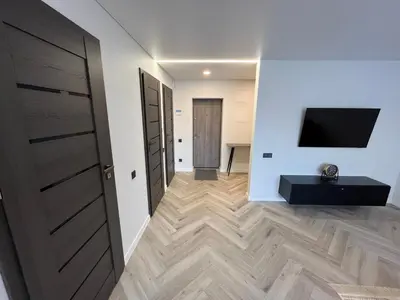 a room with a hallway with a television and a door at Modernūs apartamentai in Vilkaviškis