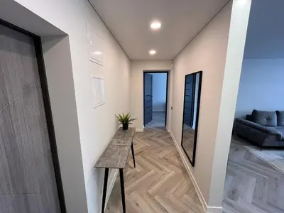 a hallway of a house with a table and a couch at Modernūs apartamentai in Vilkaviškis