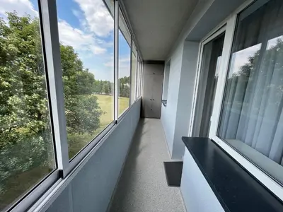 an empty hallway with large windows in a house at Modernūs apartamentai in Vilkaviškis