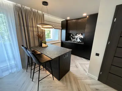a kitchen with a table and chairs in a room at Modernūs apartamentai in Vilkaviškis