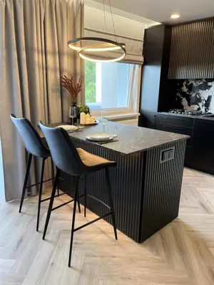 a kitchen with a island with chairs and a table at Modernūs apartamentai in Vilkaviškis