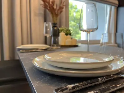 a table with plates and wine glasses on it at Modernūs apartamentai in Vilkaviškis