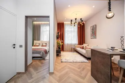 a bedroom and a living room with a bed at Poppy Apartments in Vilnius