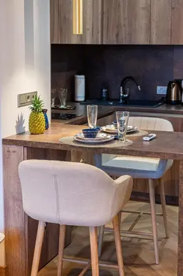 a kitchen with a wooden table with glasses on it at Poppy Apartments in Vilnius