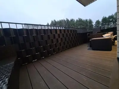 a wooden deck with a fence on a house at Riverside Retreat Near City in VNO