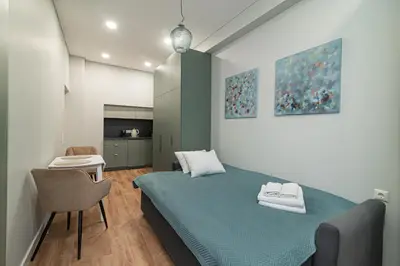 a bedroom with a bed and a table and a chair at Flowers Studio in Vilnius