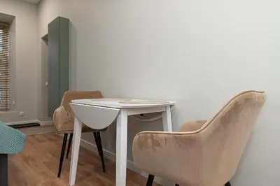 a white table and chairs in a room at Flowers Studio in Vilnius