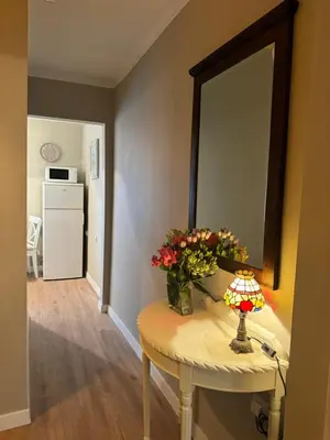 a room with a table with a mirror and flowers on it at Jaukus apartamentas Birzu centre in Biržai
