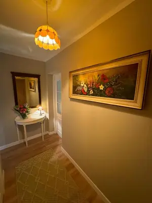 a hallway with a painting of flowers on the wall at Jaukus apartamentas Birzu centre in Biržai