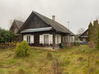 an old house sitting on a grass field at Daffaydaffay in Kruminiai