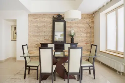 a dining room with a table and chairs and a brick wall at Luxury & Best location in Vilnius