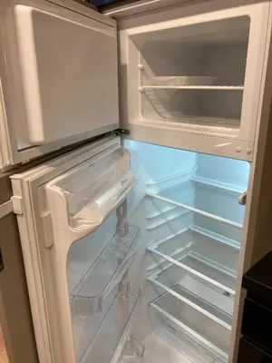 an empty refrigerator with its door open and its drawers at Kaja Home in Šiauliai