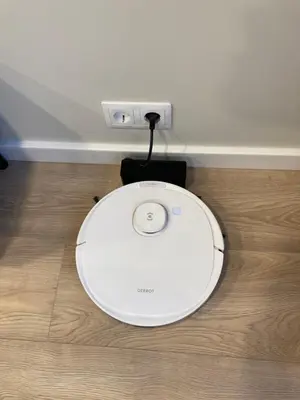 a white computer mouse sitting on top of a wooden floor at Kaja Home in Šiauliai