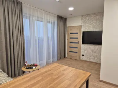 a living room with a television and a table at New Kreves apartment & Free parking & Self check-in in Kaunas