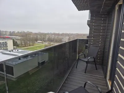 a balcony with a chair on top of a building at New Kreves apartment & Free parking & Self check-in in Kaunas