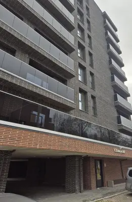 a tall building with a parking garage in front of it at New Kreves apartment & Free parking & Self check-in in Kaunas