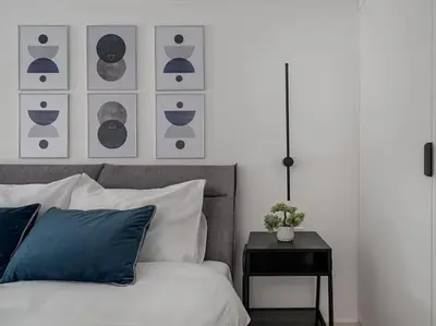 a bedroom with a bed with blue pillows and a table at Loft 59 with Free Parking in Vilnius