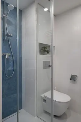a bathroom with a toilet and a glass shower at Loft 59 with Free Parking in Vilnius