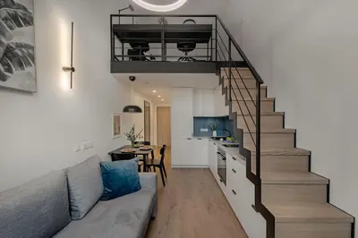 a living room with a couch and a staircase at Loft 59 with Free Parking in Vilnius