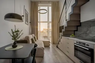 a kitchen and living room with a table and a stair at Brand New 58 Loft with Free Parking in Vilnius