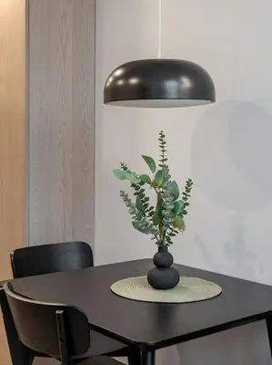 a black table with a vase with a plant on it at Brand New 58 Loft with Free Parking in Vilnius