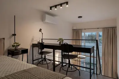 a bedroom with a table and chairs and a bed at Brand New 58 Loft with Free Parking in Vilnius