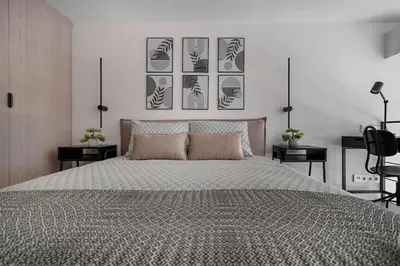 a bedroom with a large bed with four pictures on the wall at Brand New 58 Loft with Free Parking in Vilnius