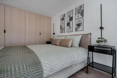 a bedroom with a bed and a desk and pictures at Brand New 58 Loft with Free Parking in Vilnius