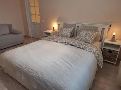 a bedroom with a large white bed with two lamps at Rinktinės apartments in Vilnius