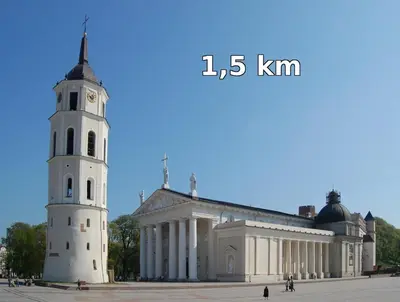 a building with a clock tower in front of it at Rinktinės apartments in Vilnius