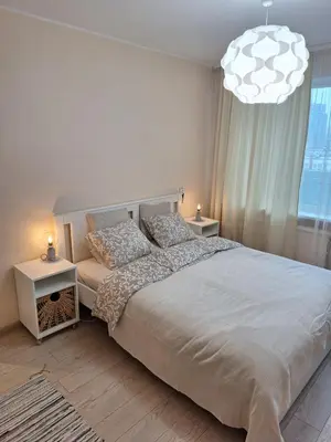 a bedroom with a large bed and a chandelier at Rinktinės apartments in Vilnius