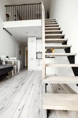 a staircase in a living room with white floors at Edvin Loft x Free parking in Vilnius