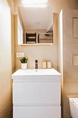 a bathroom with a white sink and a mirror at Edvin Loft x Free parking in Vilnius