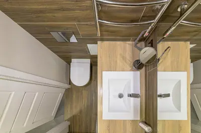 a bathroom with two white toilets and wooden floors at Town Square Apartment in Panevėžys