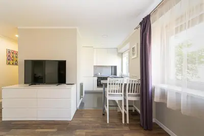 a living room with a tv and a kitchen at Town Square Apartment in Panevėžys