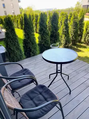 a table and two chairs on a wooden deck at Studio FAMILY like home in Vilnius