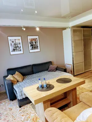 a living room with a couch and a table at Studio FAMILY like home in Vilnius