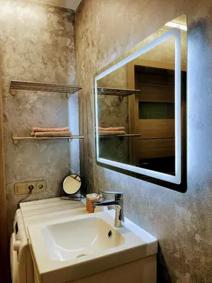 a bathroom with a sink and a mirror at Studio FAMILY like home in Vilnius
