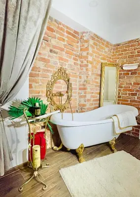 a bathroom with a white bath tub in a brick wall at IN ROOM Old town Kaunas in Kaunas