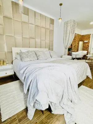 a bedroom with a large white bed with a wall at IN ROOM Old town Kaunas in Kaunas
