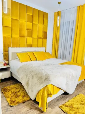 a bedroom with a large bed with yellow curtains at IN ROOM Old town Kaunas in Kaunas
