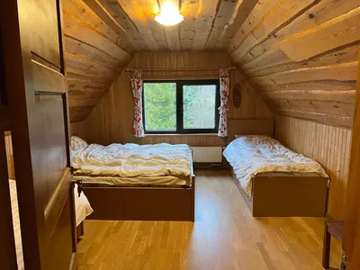 two beds in a small room in a cabin at Sodyba Žabynė in Degyany