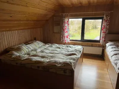 a bedroom with a bed and a window in a cabin at Sodyba Žabynė in Degyany