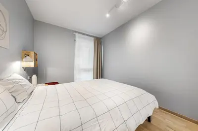 a white bedroom with a large bed and a window at Cozy 55m2 Zverynas Retreat with Lodge in Vilnius