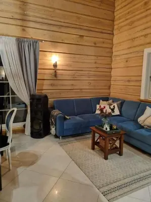 a living room with a blue couch and a table at Jauki Trobelė in Aukštelkai