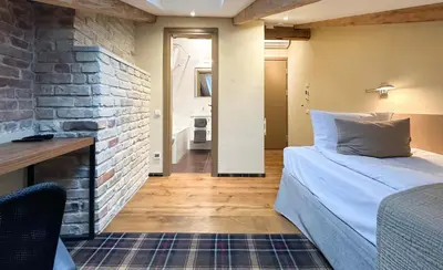 a bedroom with a bed and a brick wall at New Town Home 1 in Vilnius