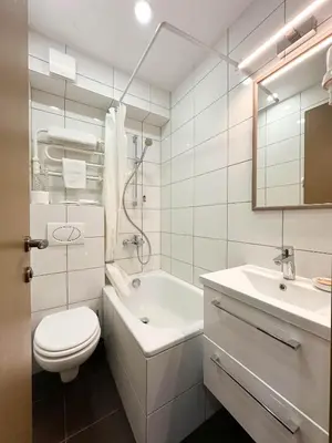 a white bathroom with a toilet and a sink at New Town Home 1 in Vilnius